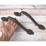 Rustic black iron barn door pull handle with decorative leaf mounting plates, heavy-duty sliding door handle for farmhouse doors, gates, cabinets, and furniture.