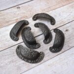 Vintage cast iron cup pull handle with antique rustic finish for cabinets, drawers, and furniture.