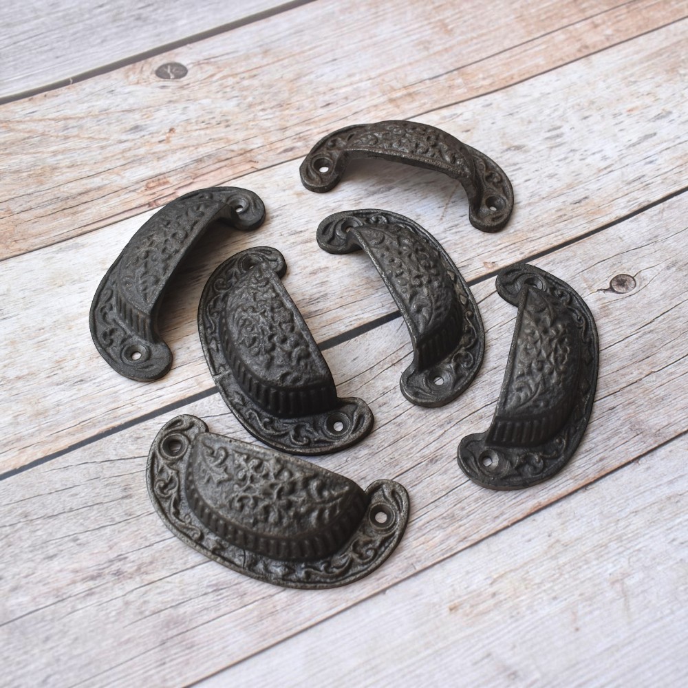 Vintage cast iron cup pull handle with antique rustic finish for cabinets, drawers, and furniture.