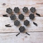 Decorative cast iron flower cabinet knobs with an antique black finish, perfect for vintage, farmhouse, and rustic furniture.