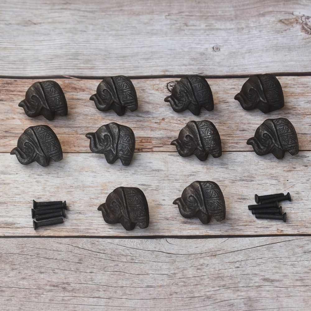 Set of 10 cast iron elephant cabinet knobs with antique black finish and mounting screws for dresser drawers, kitchen cabinets, cupboards, wardrobe doors, and rustic furniture.
