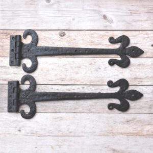 Hand forged wrought iron Fleur de Lis strap hinges with rustic black finish. Heavy-duty decorative hinges for barn doors, gates, sheds, garages, farmhouse, and restoration projects.