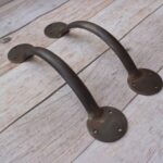 Enhance your doors with this handcrafted iron door pull handle pair. Featuring a rustic forged finish and heavy-duty construction, it's ideal for barn doors, wooden gates, entry doors, garages, and farmhouse décor.
