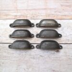 Plain cast iron cup pull handles with antique black finish for cabinets, drawers, and furniture.