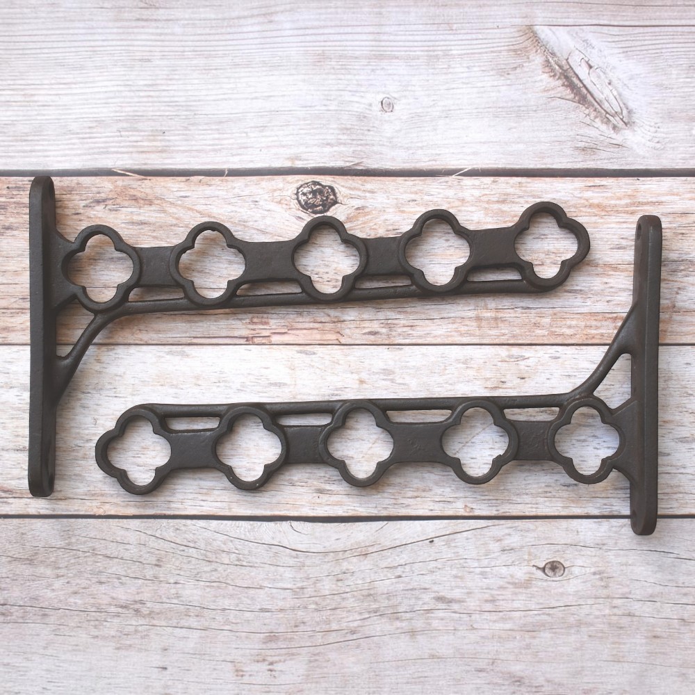 Heavy-duty cast iron hanging basket bracket with decorative quatrefoil design, antique black finish, ideal for hanging flower baskets, lanterns, bird feeders, and planters.