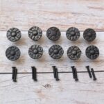 Set of 10 vintage cast iron round floral cabinet knobs with mounting screws for drawers, cabinets, wardrobes, cupboards, and furniture.