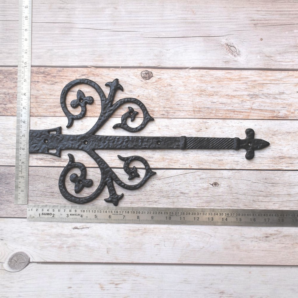 Vintage cast iron Fleur-de-Lis decorative strap hinge pair with ornate scroll design and antique black finish for barn doors, gates, shutters, and rustic farmhouse décor.