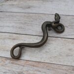 Vintage cast iron rattlesnake door pull handle with antique brass finish for barn doors, gates, cabinets, and rustic furniture.