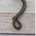Vintage cast iron rattlesnake door pull handle with antique brass finish for barn doors, gates, cabinets, and rustic furniture.