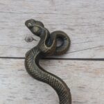 Vintage cast iron rattlesnake door pull handle with antique brass finish for barn doors, gates, cabinets, and rustic furniture.
