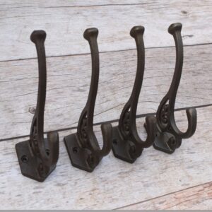 Set of 4 vintage cast iron double coat hooks with decorative detailing and dark rustic finish for coats, hats, bags, and home organization.