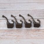 Set of 4 vintage cast iron double coat hooks with decorative detailing and dark rustic finish for coats, hats, bags, and home organization.