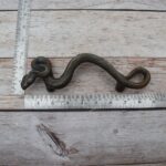 Vintage cast iron rattlesnake door pull handle with antique brass finish for barn doors, gates, cabinets, and rustic furniture.